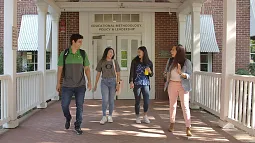 image of four students walking down walkway in front of EMPL doors