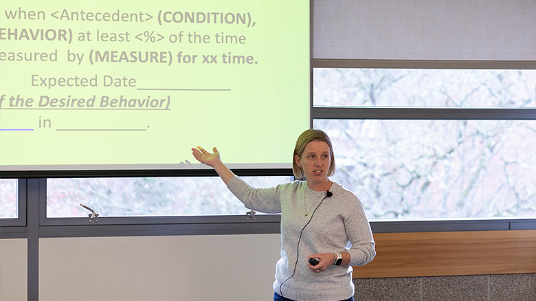 image of SPSY professor pointing to a screen in a classroom