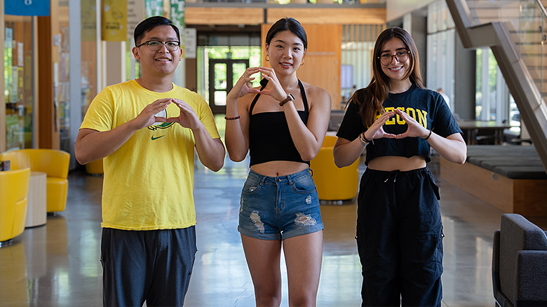 image of three UO international students making the Oregon O with their hands