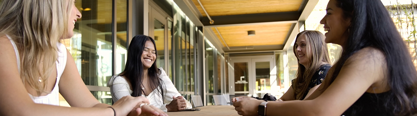 image of students sitting at a table talking