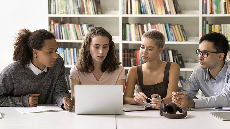 image of four individuals in a library sitting at a table