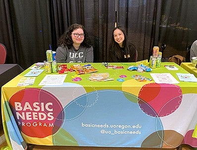 Mia Ly and student sitting at Basic Needs table