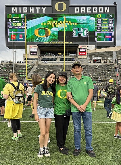image of Mia Ly at UO stadium with parents