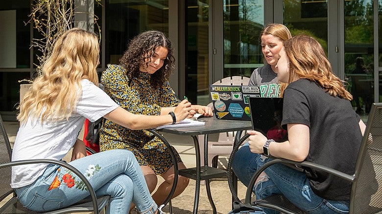 image of a group of students sitting outside of HEDCO