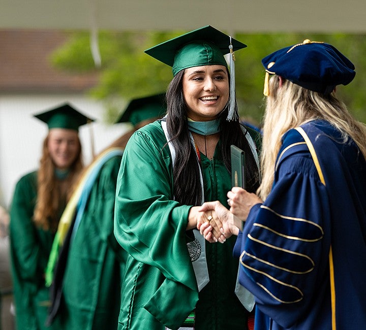 graduate shaking hand with dean of college of education