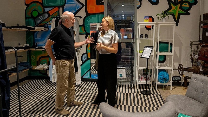 Christopher Murray standing in a room talking with an individual