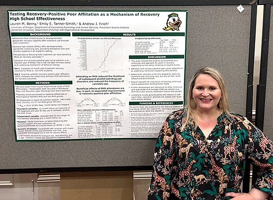 Lauren Berny standing by a poster presentation