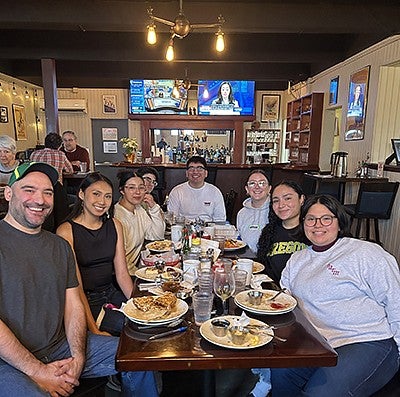 Ricardo Silas and group at a restaurant facing the camera and smiling