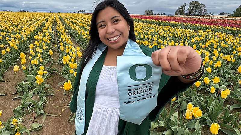 Addie Cooper holding her graduation from the COE sash