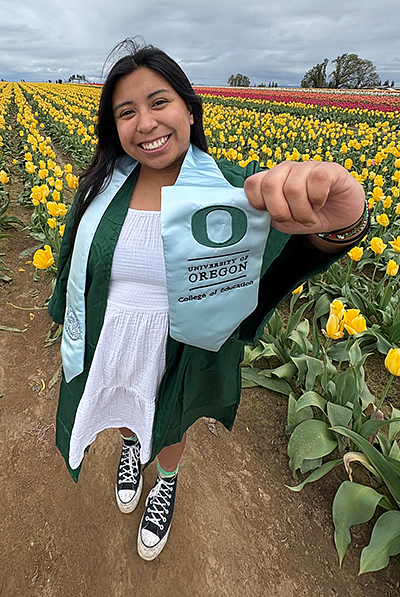 Addie Cooper holding her graduation from the COE sash