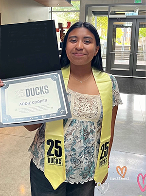Addie Cooper holding her 25 Ducks certificate from the University of Oregon