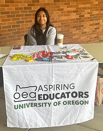 Addie Cooper sitting behind the Aspiring Educators Club table