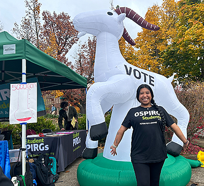 Addie Cooper in OSPIRG t-shirt standing in front of a blow up unicorn