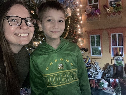Logan Holley Luna and son posing with holiday decorations in the background