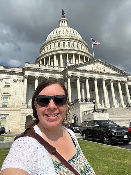 alumni Kristin Rush standing in front of a white building