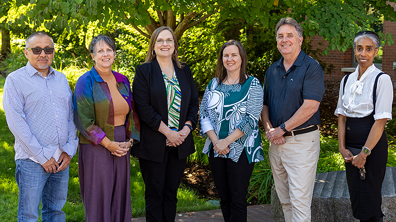 Associate Deans standing in a group facing the camera smiling