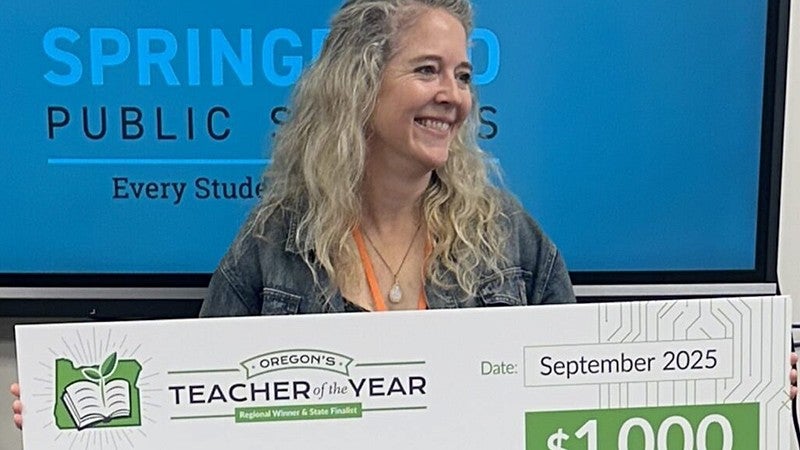 Sally Golden holding a Teacher of the Year sign