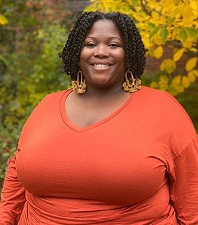 Elyse Calhoun in an orange top smiling at the camera