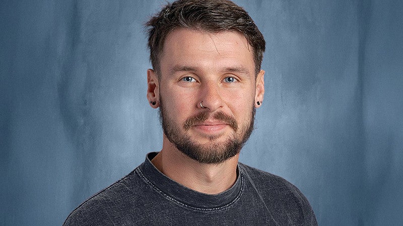 Alex Walker headshot with blue background