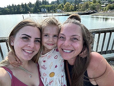 Cati Adkins and children on a bridge smiling at the camera