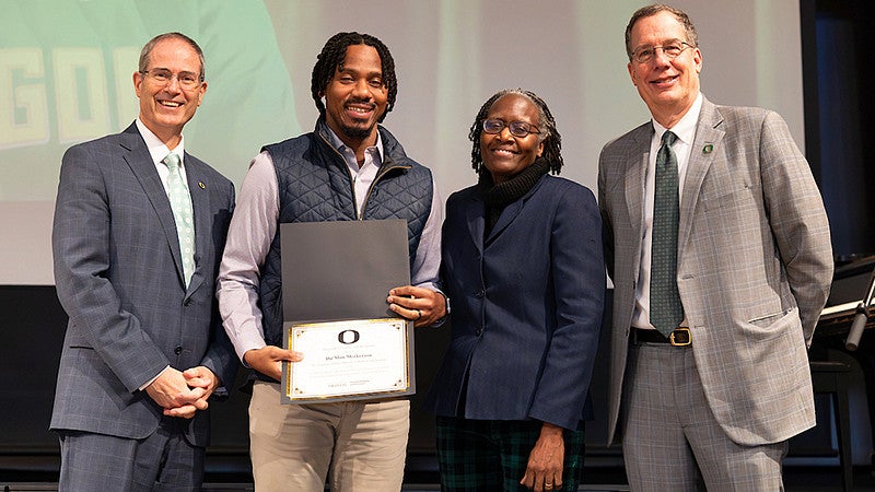 Da'Mon Merkerson holding a MLK award pictured with other individuals smiling at camera