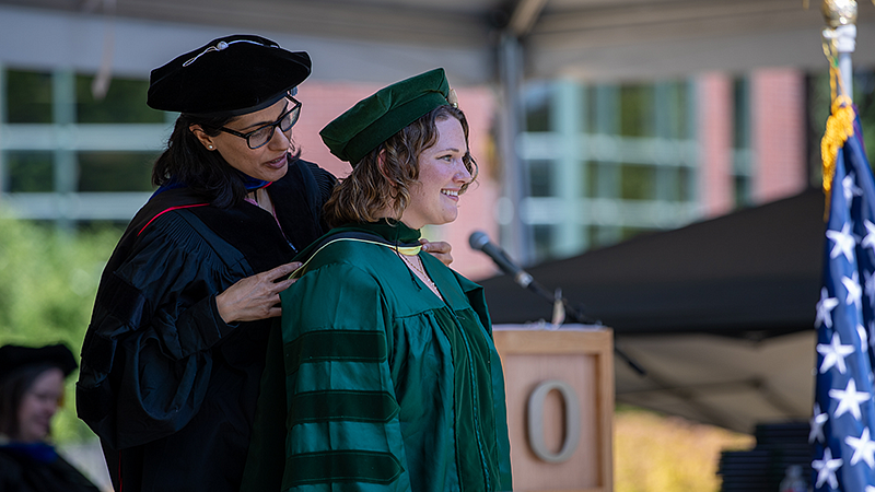 College of Education doctoral student and faculty in graduation regalia