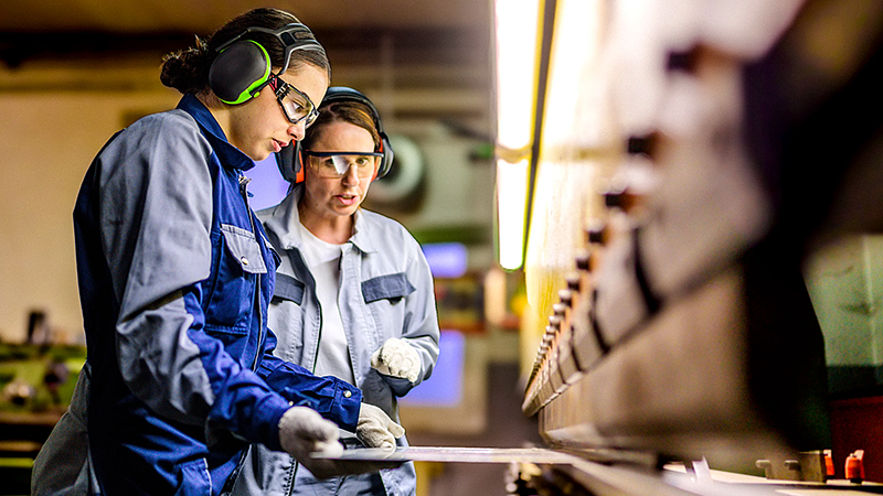 individuals wearing protective gear while standing at assembly line