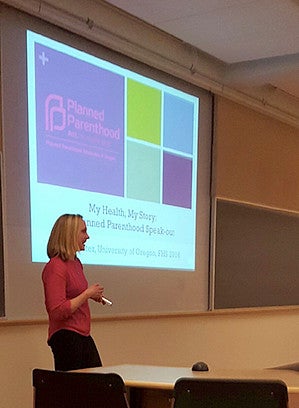 Leah Schluter standing while presenting a power point on planned parenthood
