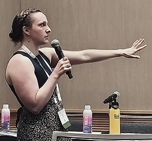 Leah Schluter standing while holding a microphone while presenting