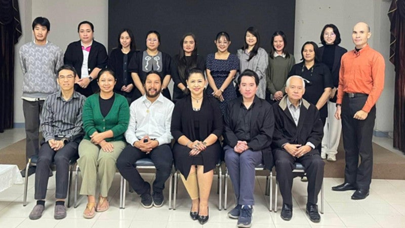 Thu Ta in a classroom of students standing together