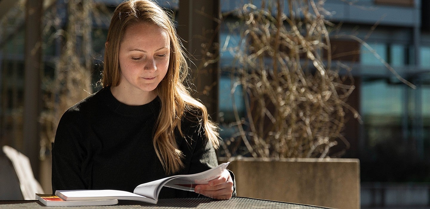 student looking down at book studying