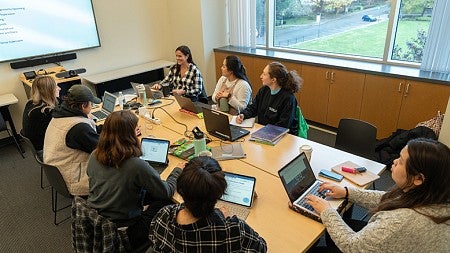 image of students sitting around a table in discussion - UO Portland campus 