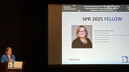 Emily Tanner-Smith, PhD standing at a podium speaking