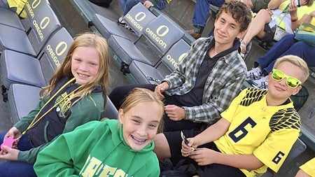Susan Coleman children sitting at UO stadium