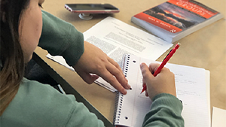 University of Oregon College of Education FHS student at desk writing