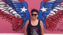 image of Alison Cerezo standing against a wall with painted red white and blue wings