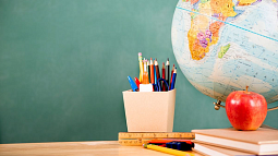 fstop123 via Getty Images image of pencil box apple and globe on a desk