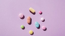 image of an assortment of pills laying on a pink background