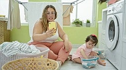 a parent and child sitting on laundry room floor