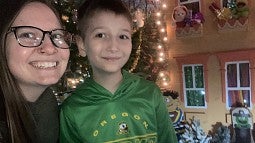 Logan Holley Luna and son posing with holiday decorations in the background