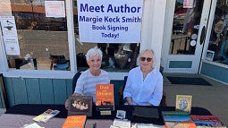 individuals sitting at a table for an author's book signing
