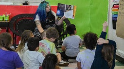 Lanelle Love reading to a group of young students in a classroom setting