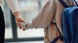Adult and child holding hands
