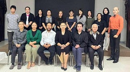 Thu Ta in a classroom of students standing together
