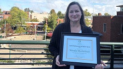 Wendy Machalicek holding an Outstanding Department Head Award from UO