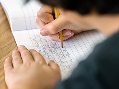 A child writing in a notebooke A child writing in a notebooke