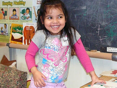 A young girl laughing in a classroom A young girl laughing in a classroom
