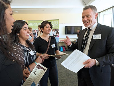 A man speaking with three women A man speaking with three women