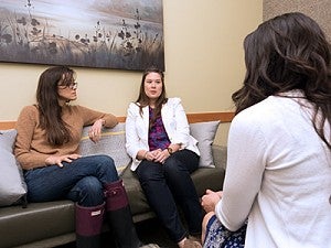 Two women speaking to a female counselor