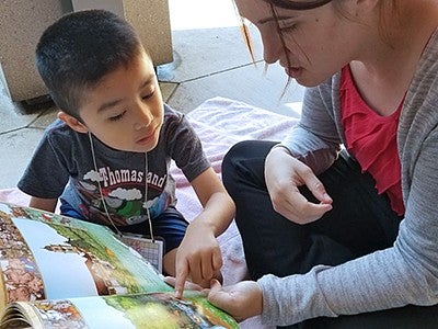 A woman reading a children's book with a young boy A woman reading a children's book with a young boy